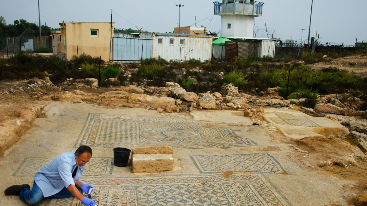 Un conservador de la Autoridad de Antigüedades de Israel trabaja en el mosaico de "Jesús" excavado en una prisión de Megiddo, en el norte de Israel, que forma parte de una estructura del siglo III o IV que podría ser una de las primeras iglesias cristianas. (Yoli Schwartz/IAA)