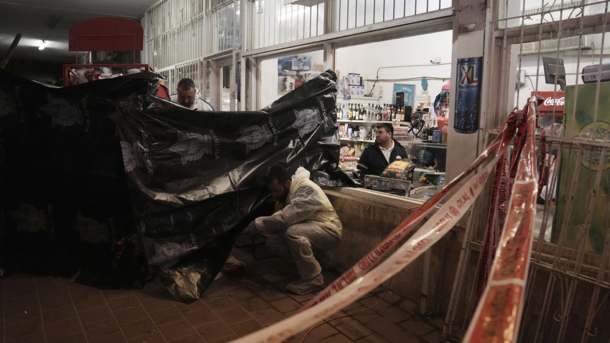 Un miembro del equipo de rescate y recuperación de Zaka limpia la sangre del lugar donde un terrorista abrió fuego en Bnei Brak, el 29 de marzo de 2022. (AP Photo/Oded Balilty)