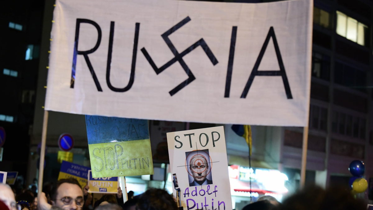 Manifestantes llevan pancartas y banderas durante una protesta contra la invasión rusa a Ucrania, frente a la embajada rusa en Tel Aviv, el 5 de marzo de 2022. (Tomer Neuberg/Flash90)