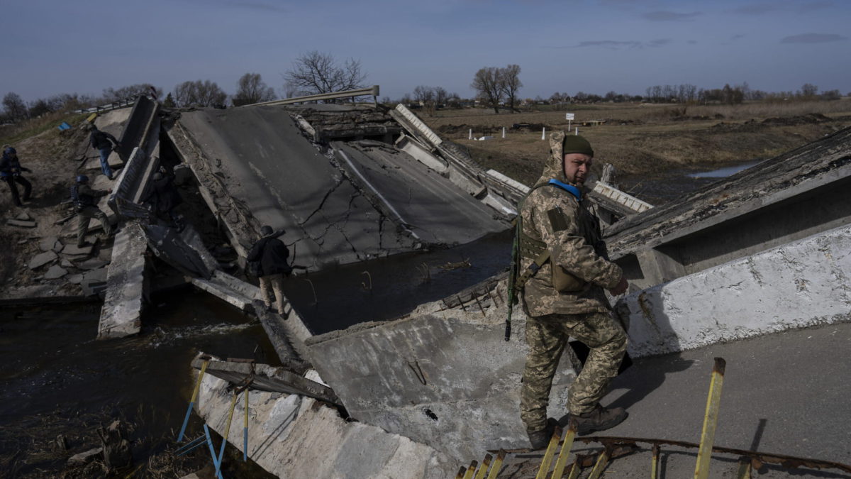 Un soldado se encuentra en un puente destruido por el ejército ucraniano para impedir el paso de los tanques rusos cerca de Brovary, en las afueras de Kiev, Ucrania, el lunes 28 de marzo de 2022. (AP Photo/Rodrigo Abd)