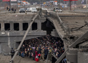 Ucranianos se agolpan bajo un puente destruido mientras intentan huir cruzando el río Irpin en las afueras de Kiev, Ucrania, el 5 de marzo de 2022. (AP Photo/Emilio Morenatti)