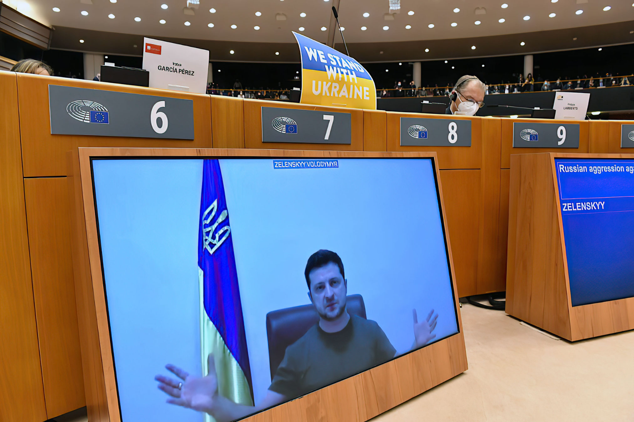 El presidente ucraniano Volodymyr Zelensky aparece en una pantalla mientras habla en una videoconferencia durante una sesión plenaria especial del Parlamento Europeo centrada en la invasión rusa de Ucrania en la sede de la UE en Bruselas, el 01 de marzo de 2022. (JOHN THYS / AFP)