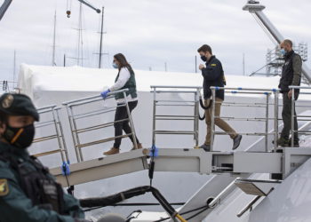 Un agente federal estadounidense y dos guardias civiles suben al yate llamado Tango en Palma de Mallorca, España, el lunes 4 de abril de 2022. (AP Photo/Francisco Ubilla)