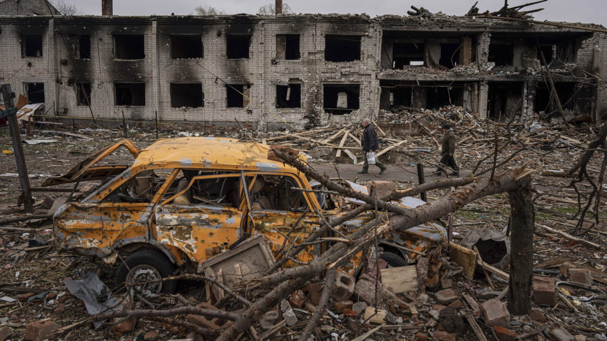 Unos hombres caminan por una calle destruida por los bombardeos en Chernihiv, Ucrania, el 13 de abril de 2022. (AP Photo/Evgeniy Maloletka)