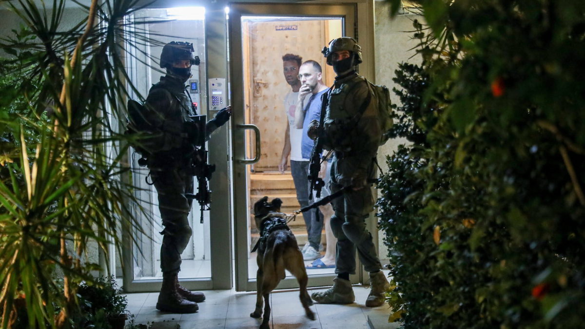 Soldados israelíes buscan cerca del lugar de un atentado terrorista en la calle Dizengoff, en el centro de Tel Aviv. Dos personas murieron y varias más resultaron heridas en el atentado, el 7 de abril de 2022. (Noam Revkin Fenton/Flash90)