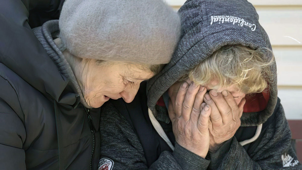 Una vecina consuela a Natalya, cuyo marido y sobrino fueron asesinados por las fuerzas rusas, mientras llora en su jardín en Bucha, Ucrania, el 4 de abril de 2022. (AP Photo/Vadim Ghirda)