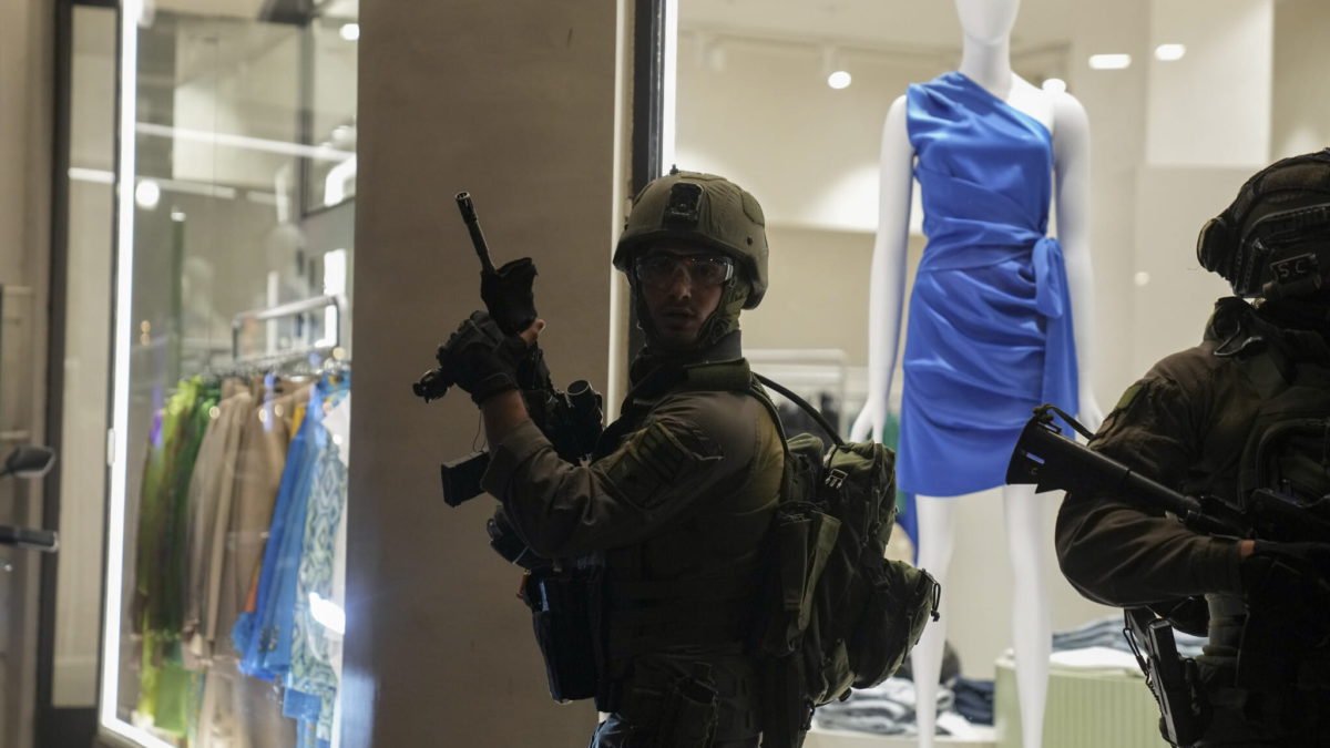 Las fuerzas de seguridad israelíes buscan a los asaltantes cerca del lugar de un ataque a tiros en Tel Aviv, Israel, el jueves 7 de abril de 2022. Las autoridades sanitarias israelíes dicen que dos personas murieron y al menos otras ocho resultaron heridas en un tiroteo en el centro de Tel Aviv. El tiroteo del jueves por la noche, el cuarto ataque en las últimas semanas, se produjo en una zona concurrida con varios bares y restaurantes. (AP Photo/Ariel Schalit)
