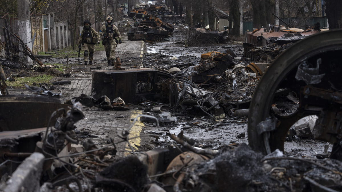 Soldados caminan entre tanques rusos destruidos en Bucha, en las afueras de Kiev, Ucrania, el domingo 3 de abril de 2022. (AP Photo/Rodrigo Abd)