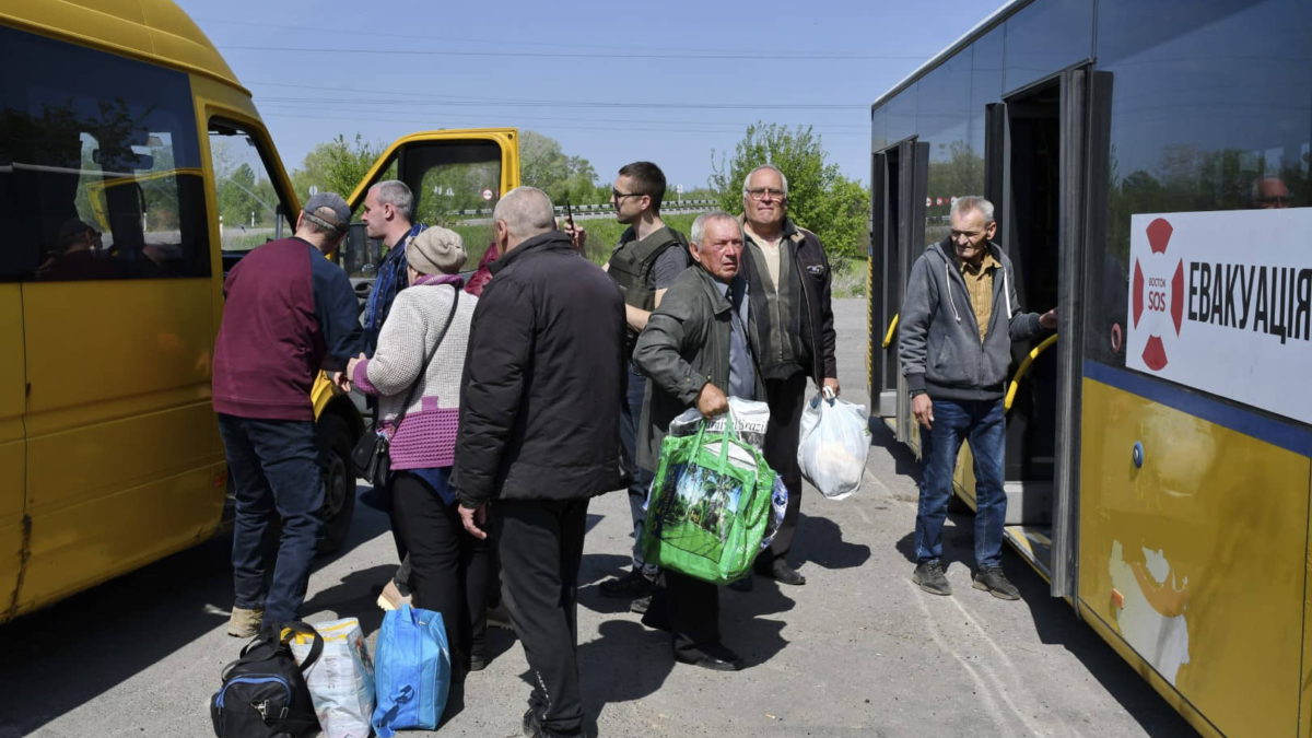 Personas suben a un autobús durante la evacuación de civiles en una carretera cerca de Slovyansk, en el este de Ucrania, el 4 de mayo de 2022. (AP Photo/Andriy Andriyenko)