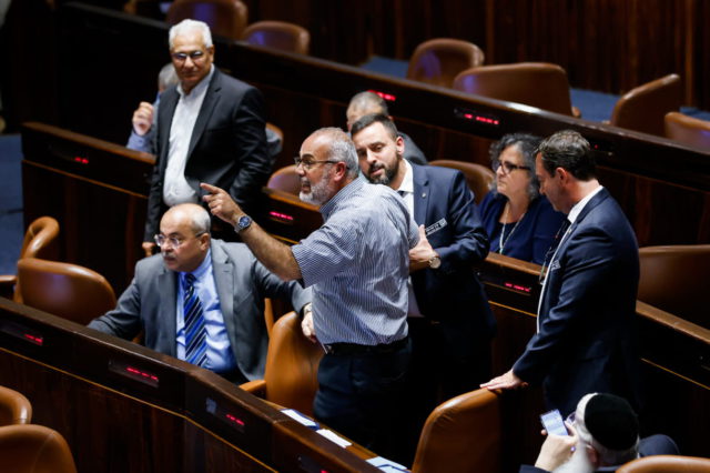 El MK de la Lista Conjunta, Sami Abou Shehadeh es expulsado de la Knesset durante una votación para prohibir que ondeen banderas palestinas en instituciones financiadas por el Estado en Jerusalén el 1 de junio de 2022. (Olivier Fitoussi/Flash90)