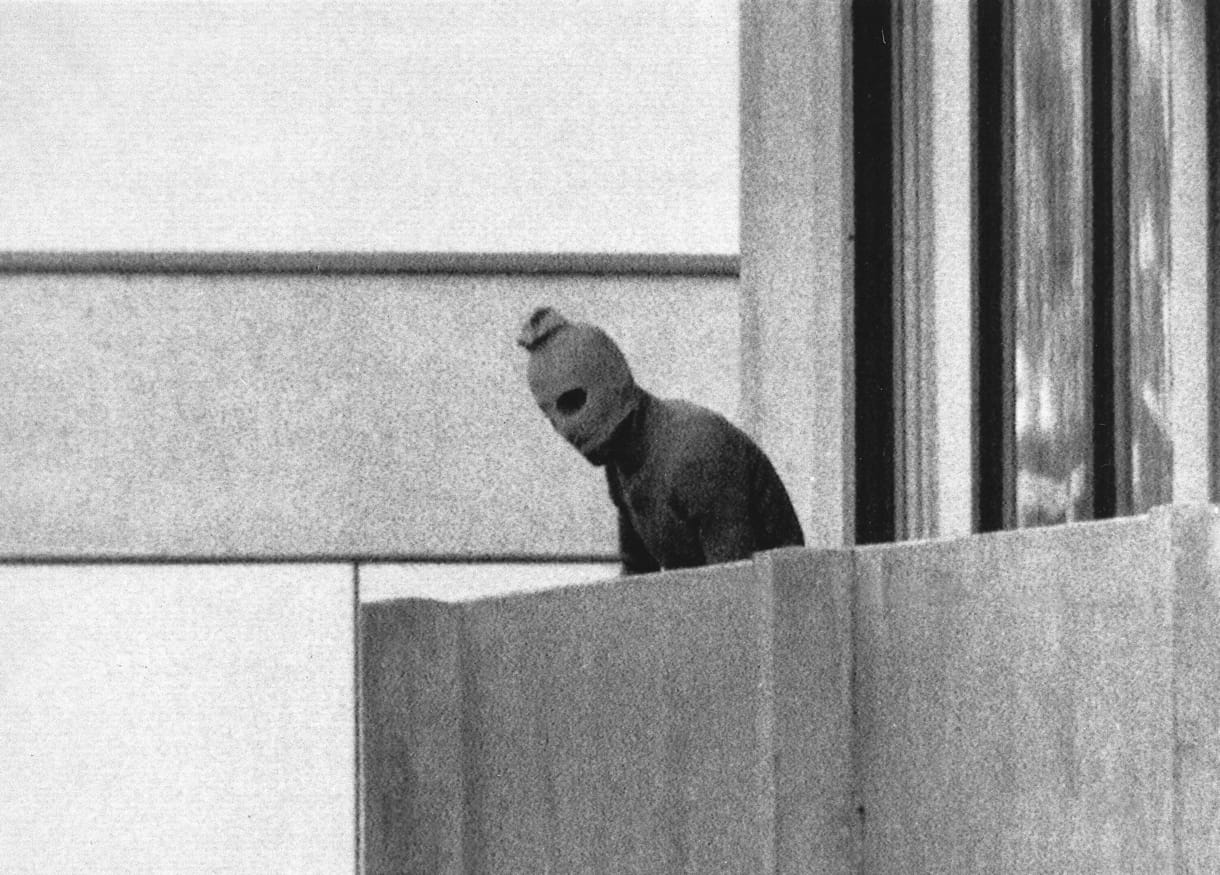 Foto de archivo del 5 de septiembre de 1972, que muestra a un miembro del grupo de comandos árabes que secuestró a miembros del equipo olímpico israelí en sus dependencias de la Villa Olímpica de Múnich, apareciendo con una capucha sobre su rostro en el balcón del edificio de la Villa donde los comandos mantuvieron como rehenes a varios miembros del equipo israelí. (AP/Kurt Strumpf, Archivo)