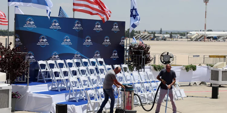 Funcionarios limpian la alfombra roja en el aeropuerto israelí Ben Gurion en Lod, cerca de Tel Aviv, el 13 de julio de 2022, antes de la llegada del presidente estadounidense Joe Biden para una visita oficial. (JACK GUEZ / AFP)