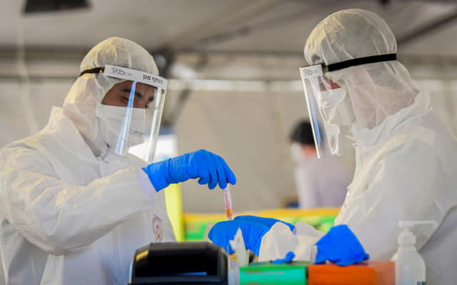 Miembros del equipo médico del Magen David Adom en un centro de pruebas de coronavirus en Tel Aviv, el 22 de marzo de 2020. (Flash90)