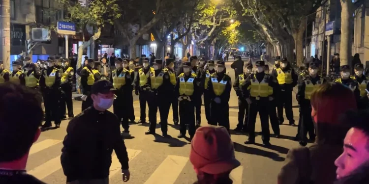 Agentes de la policía china bloquean el acceso a un lugar donde se habían reunido los manifestantes en Shanghái el 27 de noviembre de 2022. (Foto AP)