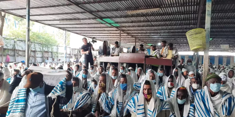 Ilustrativo: Hombres leen del rollo de la Torá durante las oraciones en la sinagoga en Gondar, Etiopía, el 31 de mayo de 2022. (Amy Spiro/Times of Israel)