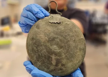 Un raro espejo de bronce descubierto en la tumba de una cortesana griega, a lo largo de Hebron Road en Jerusalén, en una fotografía publicada el 27 de septiembre de 2023. (Yoli Schwartz/Autoridad de Antigüedades de Israel)