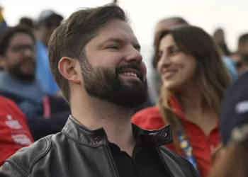 El presidente chileno Gabriel Boric celebra después de que Chile derrotara a EE.UU. en el partido por la medalla de bronce de voleibol de playa masculino, durante los Juegos Panamericanos Santiago 2023, el 27 de octubre de 2023. (Mauro Pimentel/AFP)