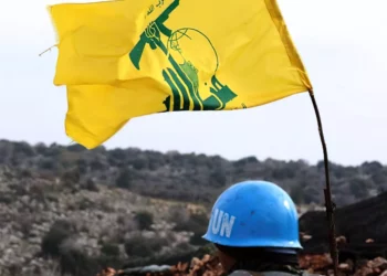 Una fotografía tomada desde la aldea sur de Líbano, Meiss al-Jabal, el 16 de diciembre de 2018, muestra a un soldado de las Fuerzas Provisionales de las Naciones Unidas en el Líbano (UNIFIL) que vigila la frontera entre el Líbano e Israel. A su derecha hay una bandera del grupo terrorista chií libanés Hezbolá. (Mahmoud Zayyat / AFP)