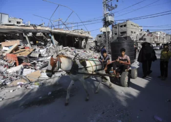 Palestinos caminan junto a la destrucción tras un ataque israelí en Rafah, Franja de Gaza, martes 31 de octubre de 2023. (AP/Hatem Ali)