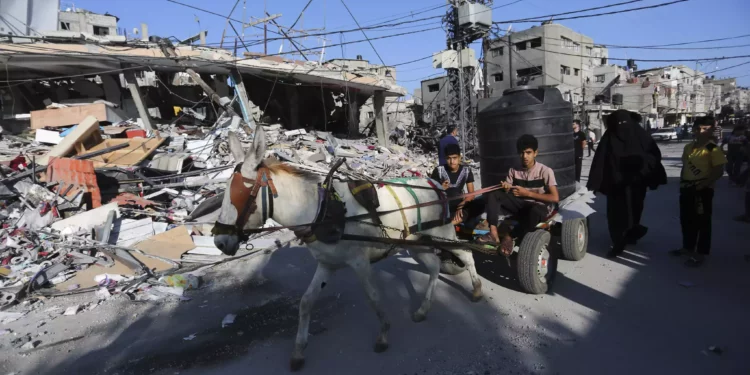 Palestinos caminan junto a la destrucción tras un ataque israelí en Rafah, Franja de Gaza, martes 31 de octubre de 2023. (AP/Hatem Ali)
