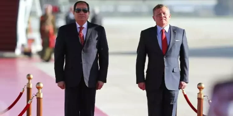 El rey Abdullah II de Jordania, a la derecha, y el presidente egipcio Abdel Fattah al-Sissi escuchan sus himnos nacionales durante una ceremonia de bienvenida a este último en el aeropuerto internacional Reina Alia de Ammán, el 28 de marzo de 2017, antes de las conversaciones en vísperas de la cumbre de la Liga Árabe. (AFP/Khalil Mazraawi)