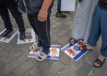 Manifestantes pisan banderas israelíes y fotos del presidente francés Emmanuel Macron y del primer ministro Benjamin Netanyahu en las que se lee 'Baby killer', cerca de la plaza Taksim de Estambul, durante una protesta contra los gobiernos europeos el 27 de octubre de 2023. (Bulent Kilic/AFP)