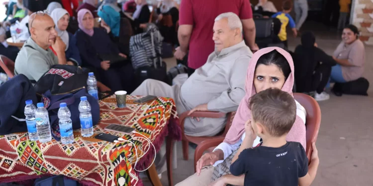 Palestinos con doble nacionalidad esperan fuera del paso fronterizo de Rafah con Egipto el 21 de octubre de 2023, mientras esperan permiso para cruzar. (Fotografía de MOHAMMED ABED / AFP)