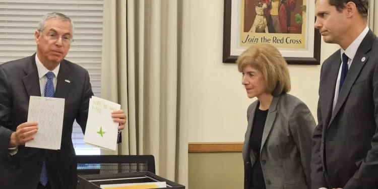 El embajador israelí en Estados Unidos, Michael Herzog, entrega tarjetas de cumpleaños para un niño israelí rehén en Gaza a dos altos cargos de la Cruz Roja Internacional en su oficina de Washington, el 24 de octubre de 2023. (Embajada de Israel en Estados Unidos)