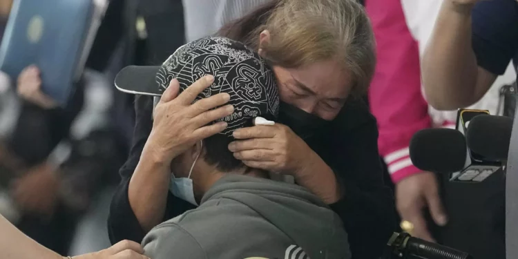 Un familiar abraza a un trabajador tailandés en el extranjero que fue evacuado de Israel tras los atentados de Hamás del 7 de octubre, mientras él y otras personas llegan al aeropuerto internacional de Suvarnabhumi, en la provincia tailandesa de Samut Prakarn, el 12 de octubre de 2023. (AP Photo/Sakchai Lalit, Archivo)