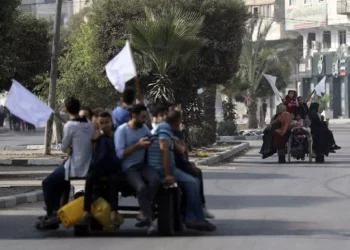 Palestinos en carros tirados por burros sostienen banderas blancas mientras huyen de la ciudad de Gaza el 8 de noviembre de 2023. (AP/Abed Khaled)