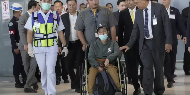 Un trabajador tailandés herido, delante en el centro, que fue evacuado de Israel, llega al aeropuerto internacional de Suvarnabhumi en la provincia de Samut Prakarn, Tailandia, 12 de octubre de 2023. (AP Photo/Sakchai Lalit)
