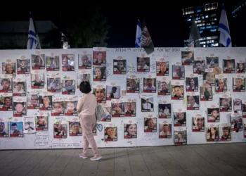 Una mujer frente a fotografías de israelíes retenidos como rehenes por terroristas de Hamás en Gaza, frente a la sede del Ministerio de Defensa en Tel Aviv, el 9 de noviembre de 2023 (Miriam Alster/FLASH90).