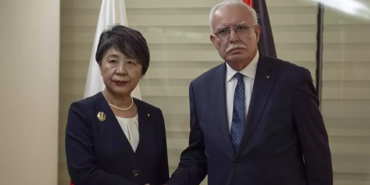 El ministro de Asuntos Exteriores de la Autoridad Palestina, Riyad al-Maliki (derecha), recibe a su homóloga japonesa, Yoko Kamikawa, en su oficina de la ciudad cisjordana de Ramala, el viernes 3 de noviembre de 2023. (AP Photo/Nasser Nasser)