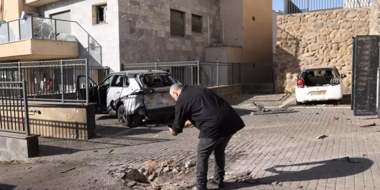 Ilustrativo: Un hombre israelí observa un pequeño cráter y vehículos dañados en Kiryat Shmona, en el norte de Israel, el 6 de noviembre de 2023. (Jalaa MAREY / AFP)