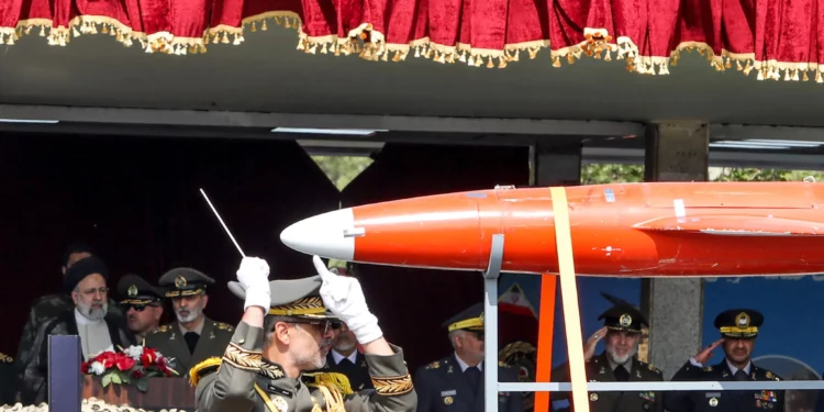 Un camión militar iraní transporta un dron Arash junto al presidente Ebrahim Raisi (izq.) y oficiales del ejército durante un desfile militar como parte de una ceremonia que marca el día anual del ejército del país en Teherán el 17 de abril de 2024. (ATTA KENARE / AFP)