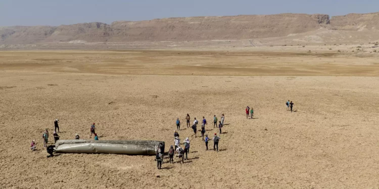 La gente se reúne alrededor de un componente de un misil balístico interceptado disparado por Irán el 14 de abril de 2024 que cayó cerca del Mar Muerto, el 20 de abril de 2024 (AP Foto/Itamar Grinberg)