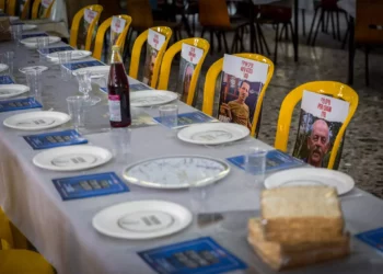 Fotos de rehenes del Kibbutz Nir Oz colocados en sillas y mesas durante un evento previo a Pesaj en el comedor del kibutz el 11 de abril de 2024. (Foto de Liron Moldovan/Flash90)