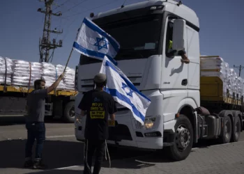 Archivo: Personas con banderas israelíes se paran frente a camiones que transportan ayuda humanitaria mientras intentan impedirles ingresar a la Franja de Gaza cerca del cruce fronterizo de Kerem Shalom, el 9 de mayo de 2024. (Foto AP/Leo Correa)