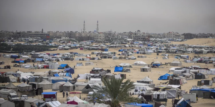 Palestinos desplazados por la guerra en curso en la Franja de Gaza caminan por un campamento improvisado en Rafah, el 10 de mayo de 2024. (AP Foto/Abdel Kareem Hana)