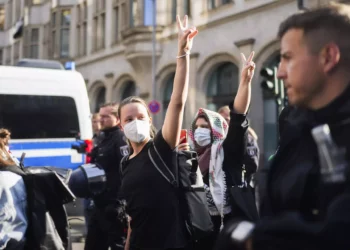 Manifestantes propalestinos y antiisraelíes que muestran el signo de la victoria son escoltados por la policía alemana cuando salen de un edificio de la Universidad Humboldt en Berlín, el 23 de mayo de 2024. (AP Foto/Markus Schreiber)