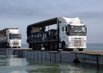 Camiones cargados con ayuda humanitaria de los Emiratos Árabes Unidos y la Agencia de los Estados Unidos para el Desarrollo Internacional cruzan el muelle Trident antes de entrar en la playa de Gaza, el 17 de mayo de 2024. (Sargento Malcolm Cohens-Ashley/US Army Central vía AP)