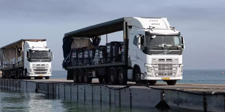 Camiones cargados con ayuda humanitaria de los Emiratos Árabes Unidos y la Agencia de los Estados Unidos para el Desarrollo Internacional cruzan el muelle Trident antes de entrar en la playa de Gaza, el 17 de mayo de 2024. (Sargento Malcolm Cohens-Ashley/US Army Central vía AP)