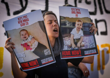 Un estudiante israelí sostiene fotografías de rehenes durante una protesta pidiendo su liberación cerca de la Knéset en Jerusalén, el 13 de junio de 2024. (Chaim Goldberg/Flash90)