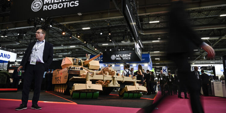 Los visitantes pasan junto a un vehículo de combate robótico Tipo-X expuesto en la feria internacional de seguridad, defensa aérea y tierra Eurosatory, en Villepinte, un suburbio al norte de París, el 17 de junio de 2024. (JULIEN DE ROSA / AFP)