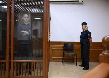 El periodista estadounidense Evan Gershkovich, acusado de espionaje, mira desde el interior de una jaula de cristal para los acusados ​​antes de una audiencia en el Tribunal Regional de Sverdlovsk de Ekaterimburgo el 26 de junio de 2024. (Natalia Kolesnikova/AFP)