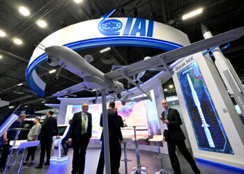 Los visitantes se encuentran en el stand de Israel Aerospace Industries (IAI) en la feria internacional de defensa y seguridad terrestre y aérea Eurosatory, en Villepinte, un suburbio al norte de París, el 13 de junio de 2022. (Emmanuel Dunand/AFP)