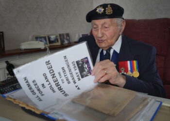 Mervyn Kersh, un veterano judío de la Segunda Guerra Mundial que participó en la Campaña de Normandía de 1944, examina documentos y periódicos de la Segunda Guerra Mundial en su casa de Londres, Gran Bretaña, el 8 de abril de 2024. (Foto AP/Kirsty Wigglesworth)