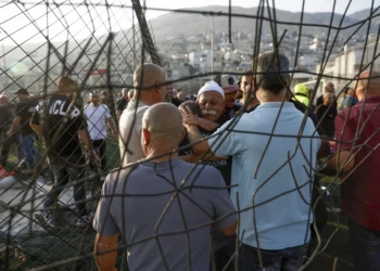 Los residentes locales se consuelan unos a otros mientras se reúnen en el lugar de un ataque con cohetes de Hezbolá en la ciudad drusa de Majdal Shams, en el norte de Israel, el 27 de julio de 2024. (Jalaa Marey/AFP)