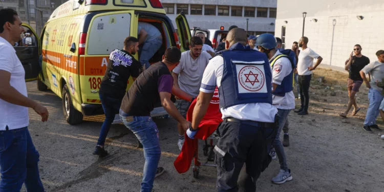 Las fuerzas de seguridad israelíes y los médicos trasladan a las víctimas de un campo de fútbol donde un cohete disparado por Hezbolá en el Líbano mató al menos a 12 jóvenes en Majdal Shams, en los Altos del Golán, el 27 de julio de 2024. (Jalaa MAREY / AFP)