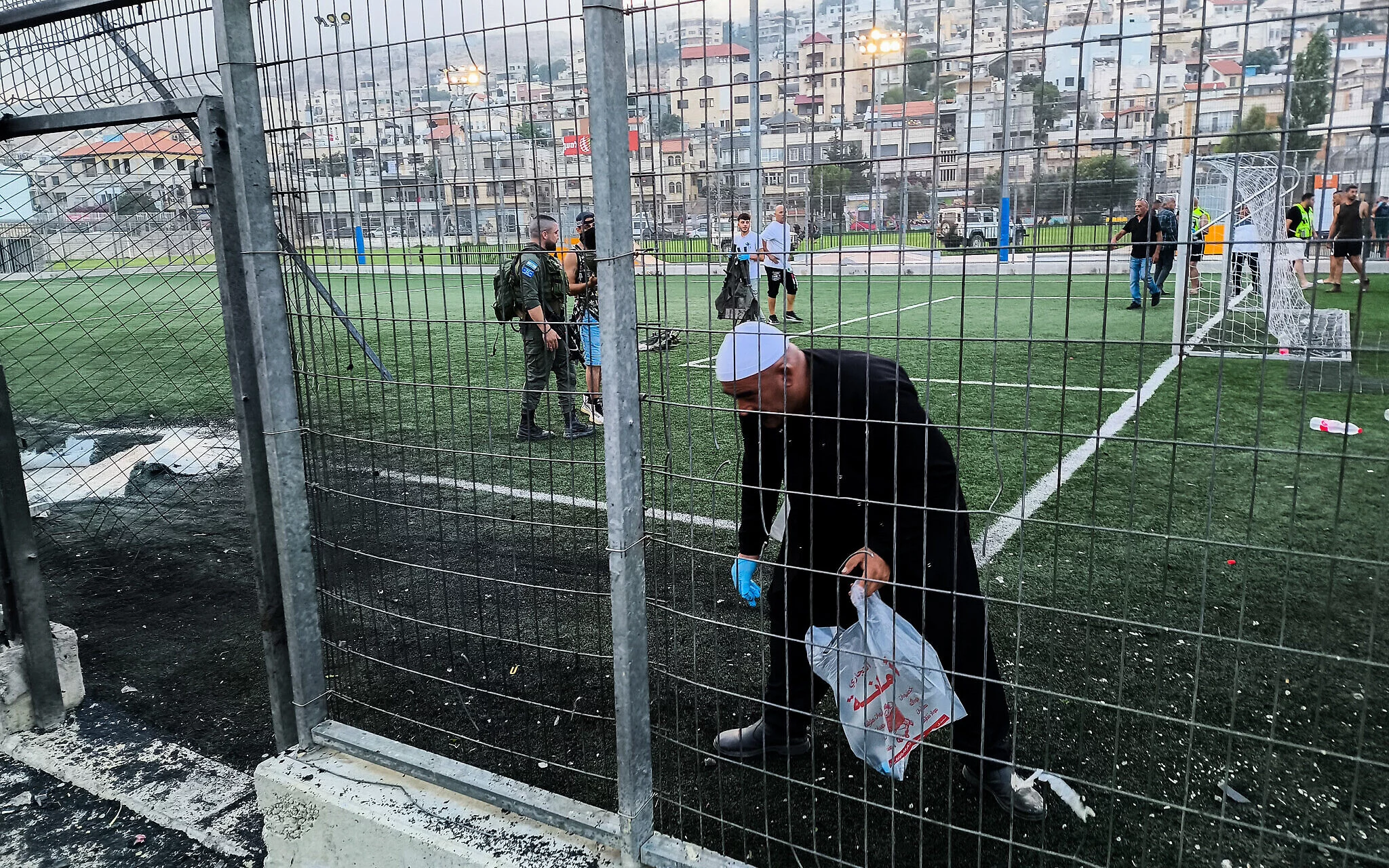 Fuerzas de rescate israelíes y residentes locales en el lugar de un ataque mortal con cohetes de Hezbolá contra un campo de fútbol en la ciudad drusa de Majdal Shams, en el norte de los Altos del Golán, el 27 de julio de 2024. (Michael Giladi/Flash90)